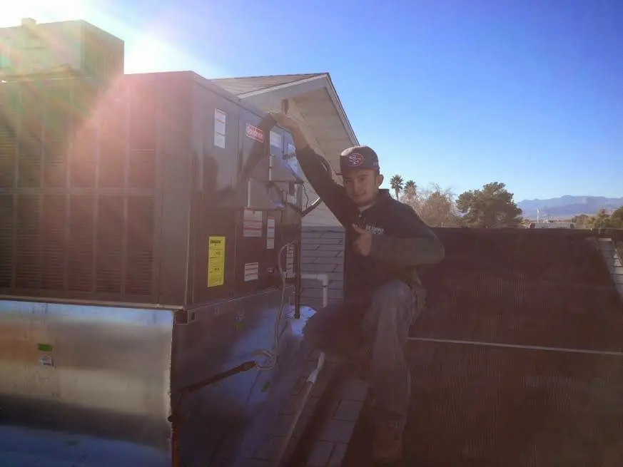 HVAC technician performing Heat Pump Repair on a rooftop unit in Cherry Hills Village